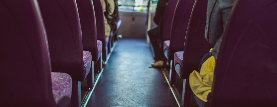 Row of purple bus seats and the bus flooring