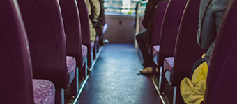 Row of purple bus seats and the bus flooring