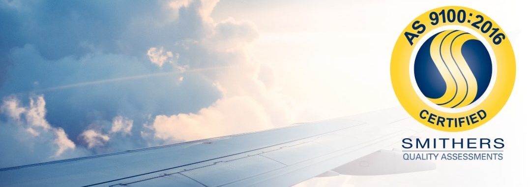 The wing of a aircraft mid-flight with the SAI Global AS9100 Certified System logo