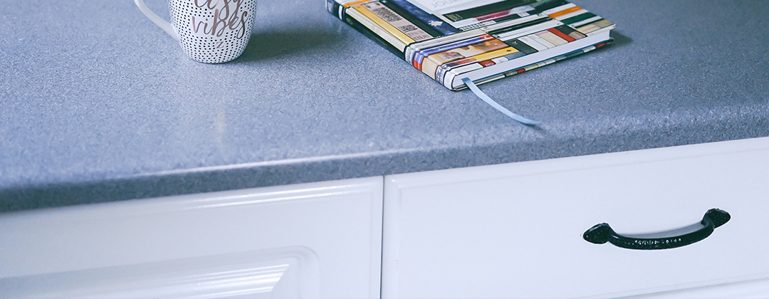 Blue countertop with notebook and coffee mug