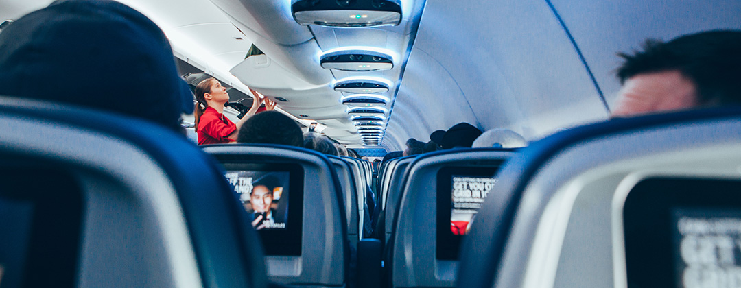 Flight attendant closing overhead compartments