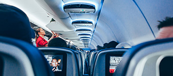 Flight attendant closing overhead compartments