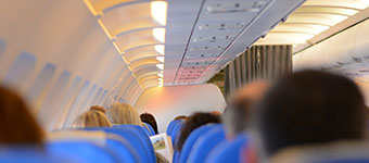 Longview of the interior of airplane, showing the tops of seats and the backs of people's heads.